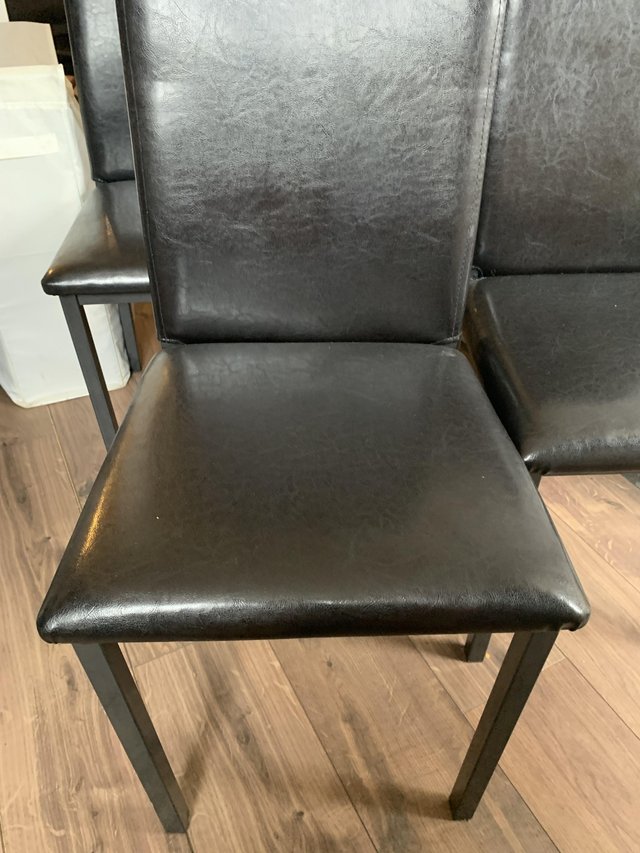 Preview of the first image of Four black faux leather dining chairs.