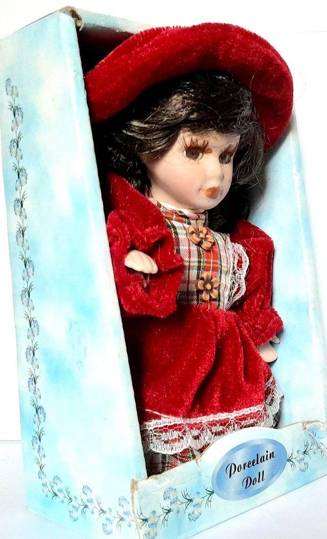 Preview of the first image of BOXED PORCELAIN DOLL - SAM in RED DRESS - 16 cm.