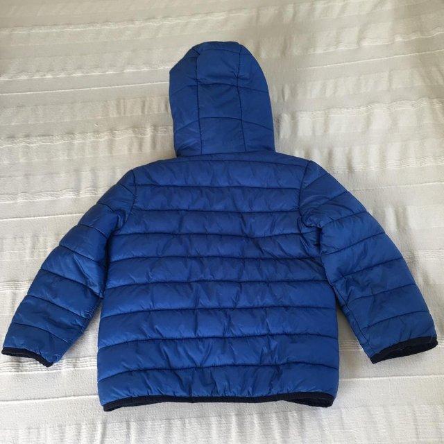 Preview of the first image of Tissaia blue packaway jacket + bag. Hood, padded. Age 6 yrs..