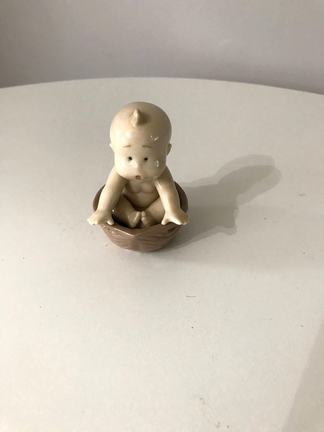 Preview of the first image of Lladro Baby In A Nut Vintage Figurine.