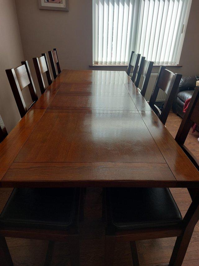 Preview of the first image of Solid wood.extending dining table and 8 chairs.