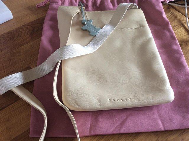 Preview of the first image of Radley cream messenger bag with pink dust bag..