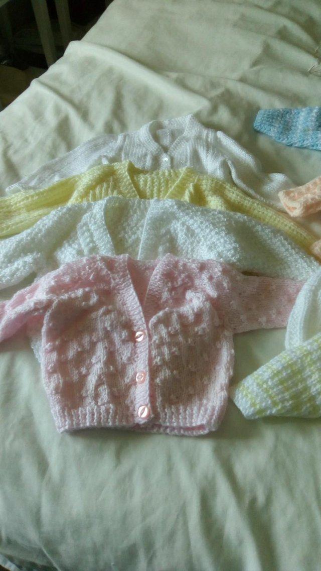Preview of the first image of Baby Cardigans Hand Knitted proceeds to St Peters Hospice.