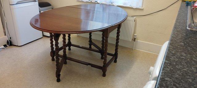 Preview of the first image of Vintage oval solid oak barley twist drop leaf dining table.