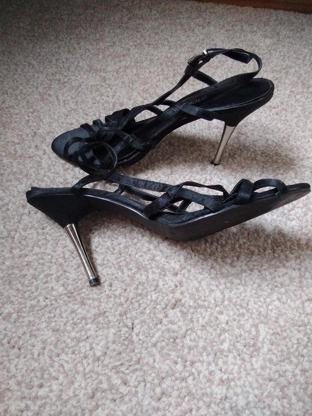 Preview of the first image of Ladies black Satin high heel sandals with metal heels.