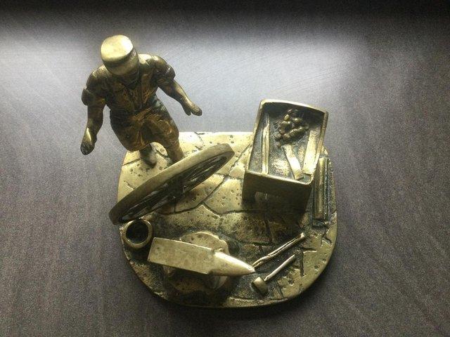 Preview of the first image of Vintage Brass Sculpture of a Blacksmith with wagon wheel.