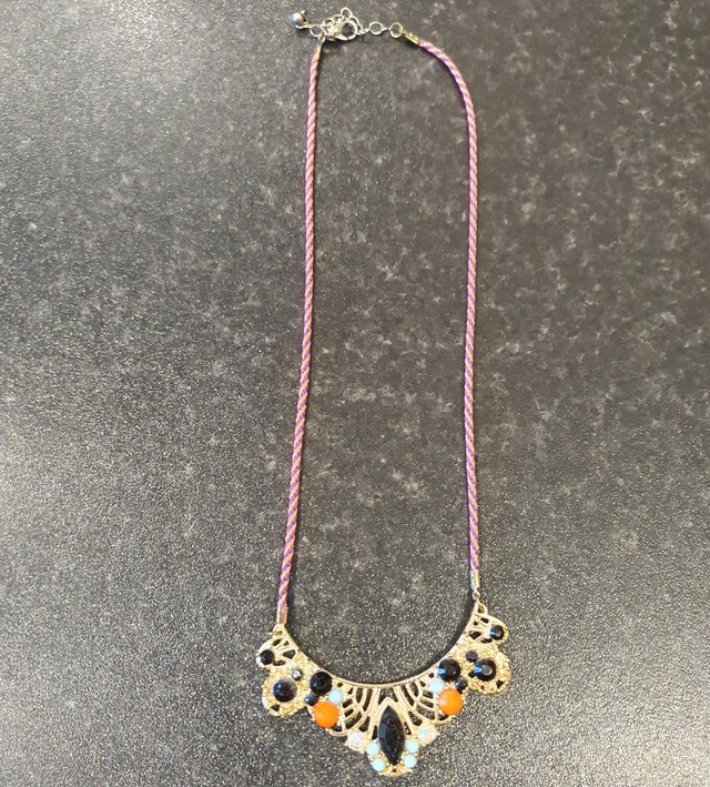 Preview of the first image of Gold colour necklace with orange, black & blue gemstones.