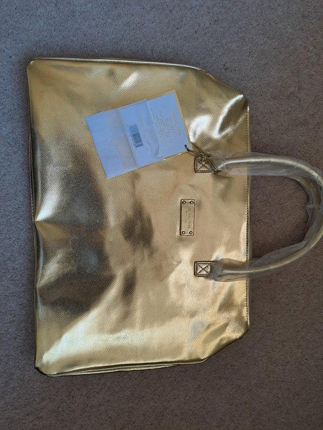 Preview of the first image of Michael Kors large gold handbag.