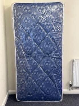 Preview of the first image of 9’inch deep filled quilted mattress in a blue football fabri.