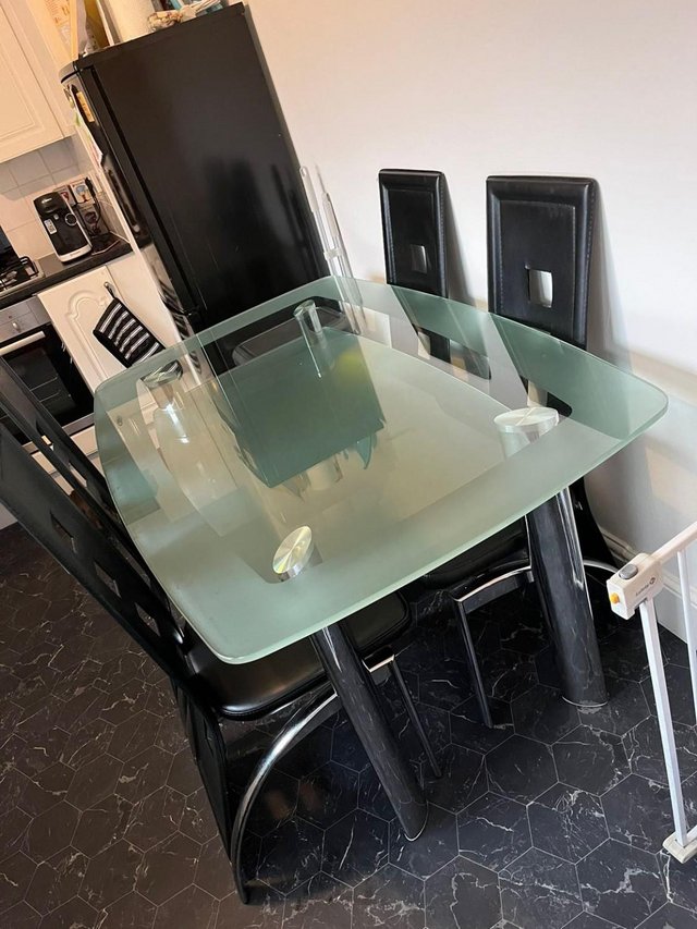 Preview of the first image of Stylish 2 tier curved glass dining table with 4 chairs.