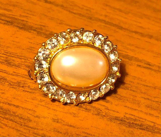 Preview of the first image of VINTAGE OVAL BROOCH WITH PEARL EFFECT CENTRE STONE.