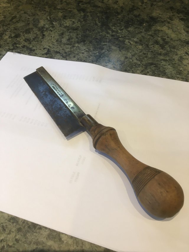 Preview of the first image of A carpenter’s vintage small hand saw with turned handle..