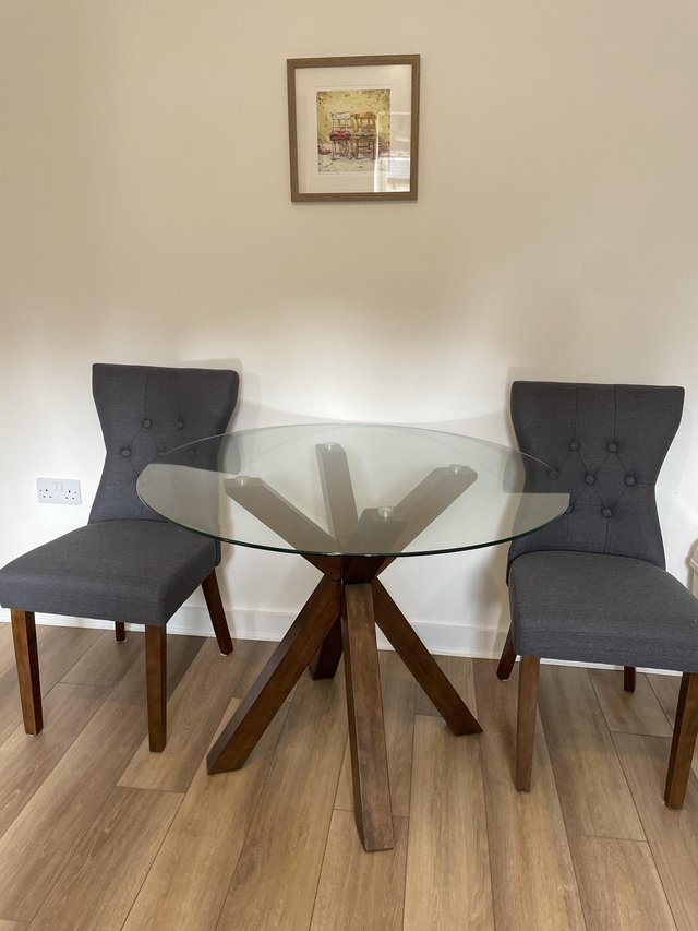 Preview of the first image of Glass top dining table and two chairs.