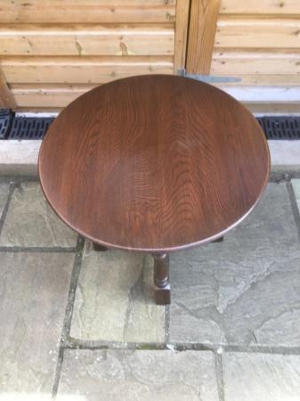 Image 3 of A small , round, wooden coffee table with turned legs.