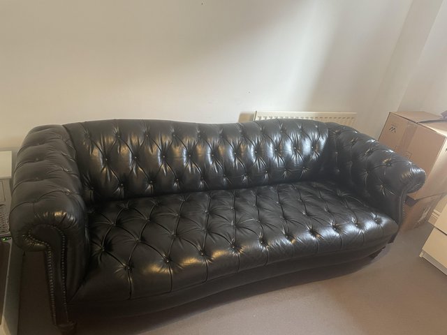 Preview of the first image of DFS black leather chesterfield sofa.