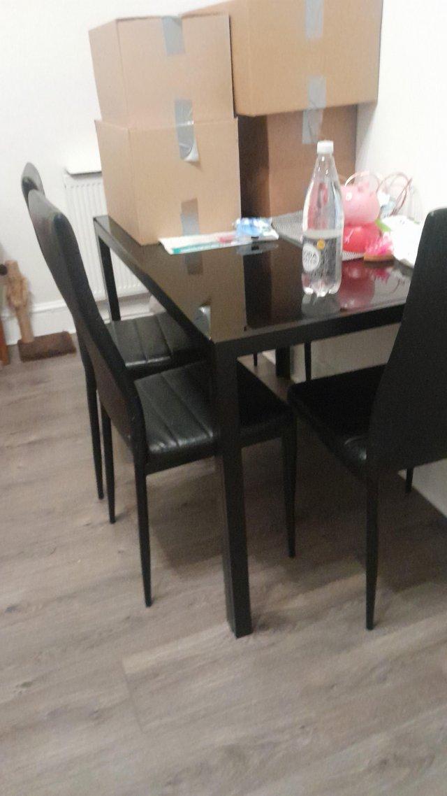 Preview of the first image of Black glass dining table and 4 chairs.