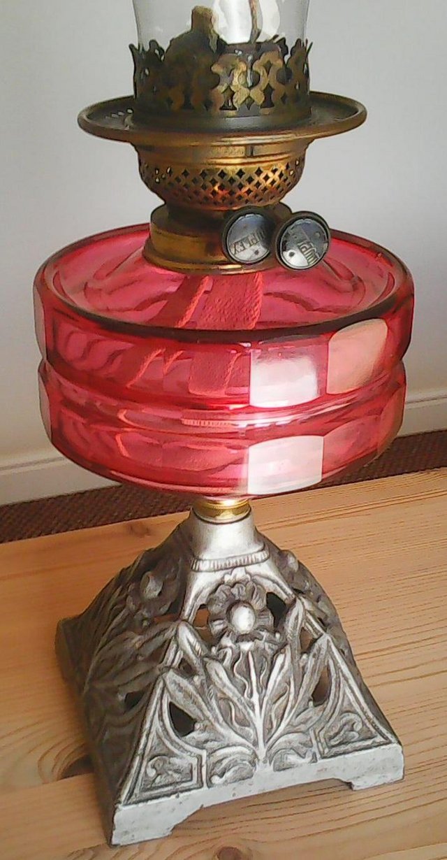 Preview of the first image of Vintage oil lamp with 'cranberry' coloured glass reservoir.