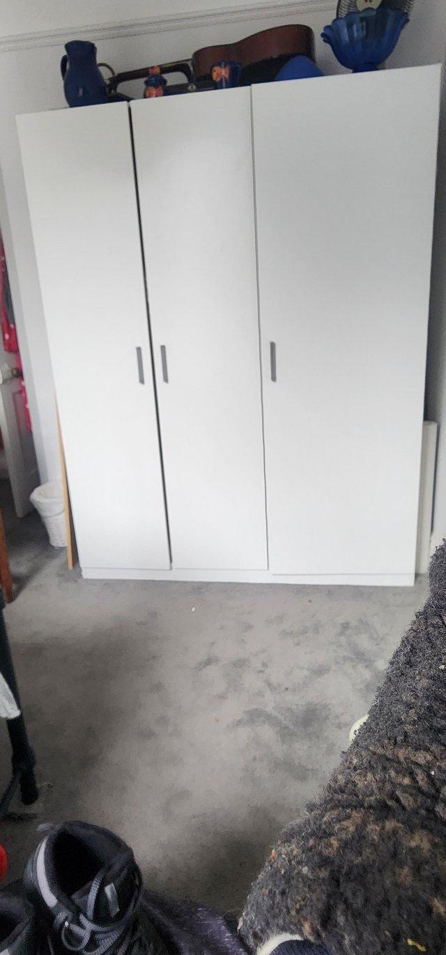 Preview of the first image of IKEA white three-door wardrobe with shelves.
