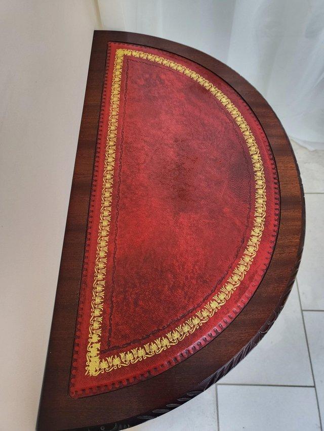 Preview of the first image of Half moon red leather inset top table.