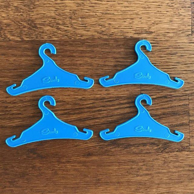 Preview of the first image of 4 vintage 1980's Sindy Doll blue plastic hangers..