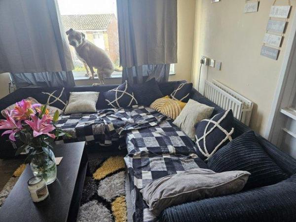 Image 3 of Grey corner sofa. Dog has chewed under the cushion