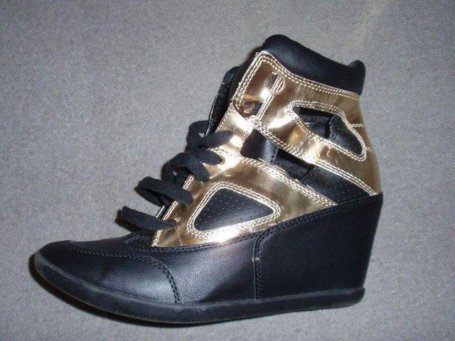 Preview of the first image of Black and Gold Wedge Trainers from Forever 21.
