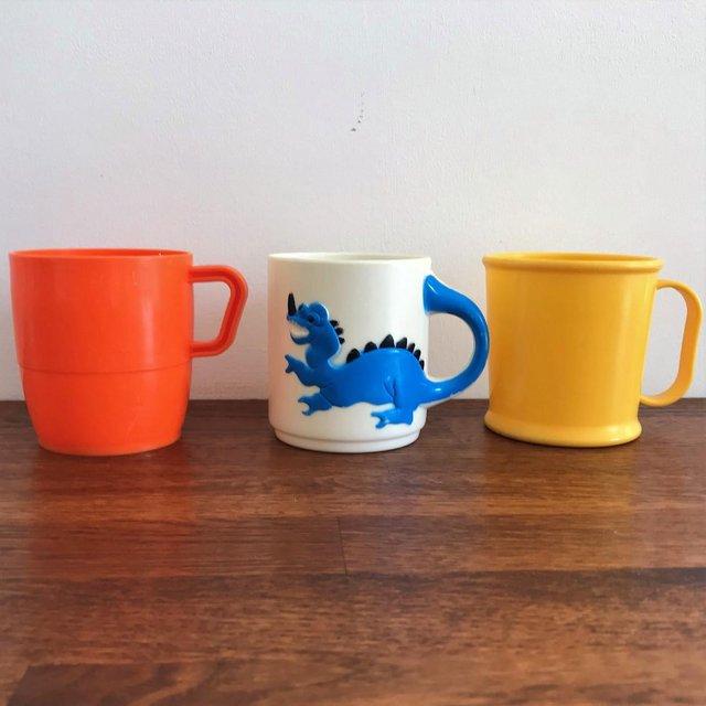 Preview of the first image of 3 vintage child's plastic mugs-dragon design, yellow, orange.