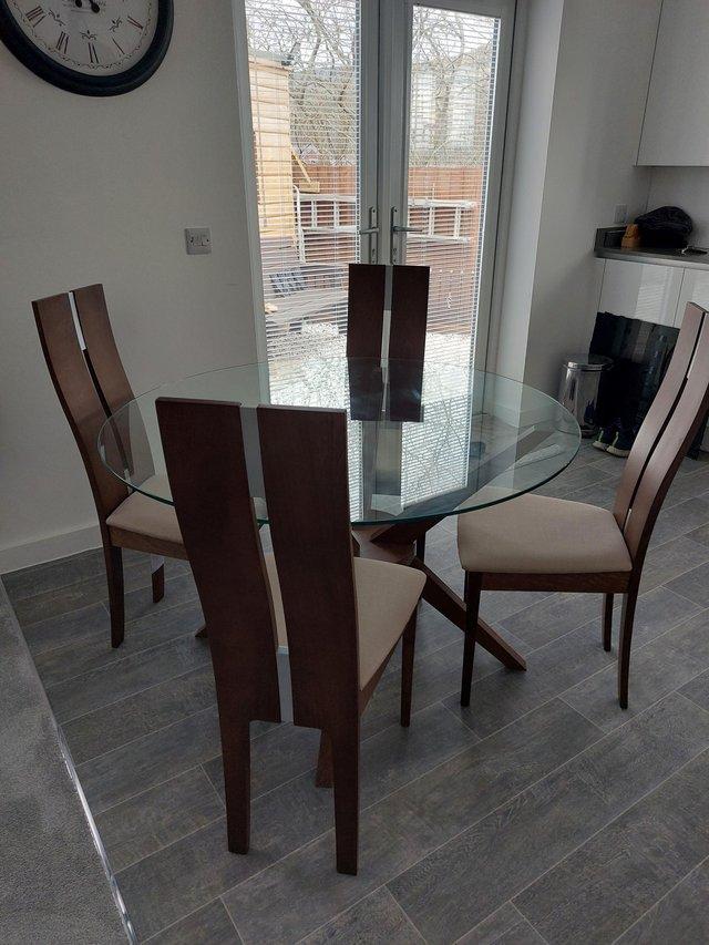 Preview of the first image of Modern glass topped dining table and 4 chairs.
