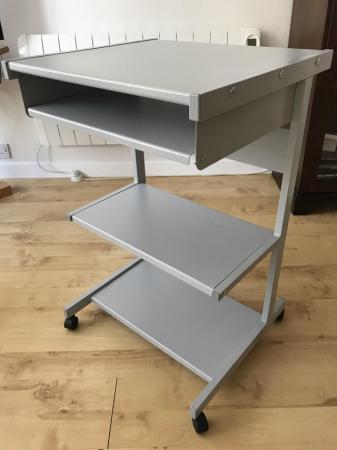 Image 1 of Grey metal computer desk unit with storage shelves.