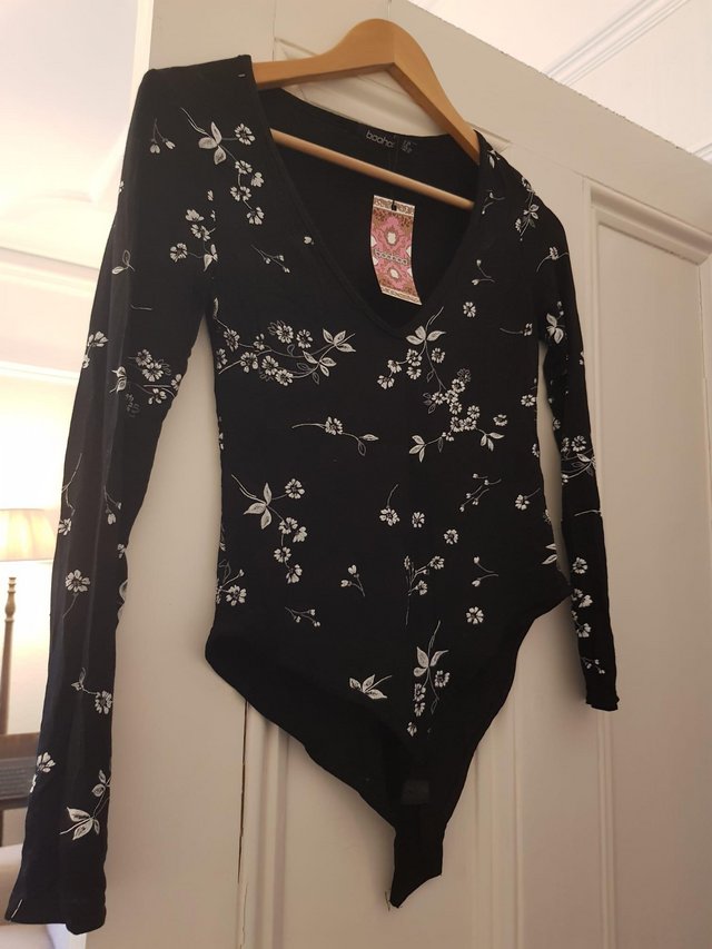 Preview of the first image of Boohoo Women's Black Floral Long Sleeved Bodysuit - unworn.