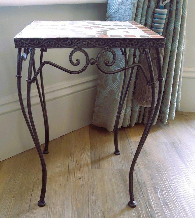 Preview of the first image of Small metal table with tiled top and detailed legs.