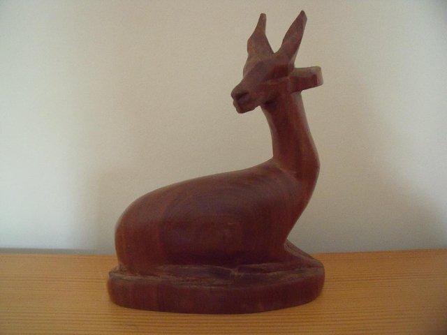 Preview of the first image of Vintage hand carved wooden deer/antelope in sitting position.