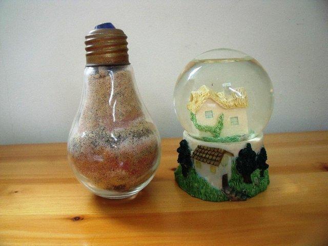 Preview of the first image of 2 ornaments: sand filled light bulb shape and glitter globe.