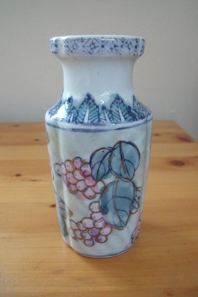 Preview of the first image of Small iridescent blue/green/pink/gilded berry & leaves vase..