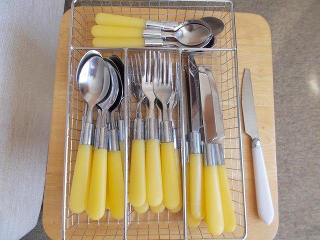Preview of the first image of Tray of yellow, plastic handled cutlery.