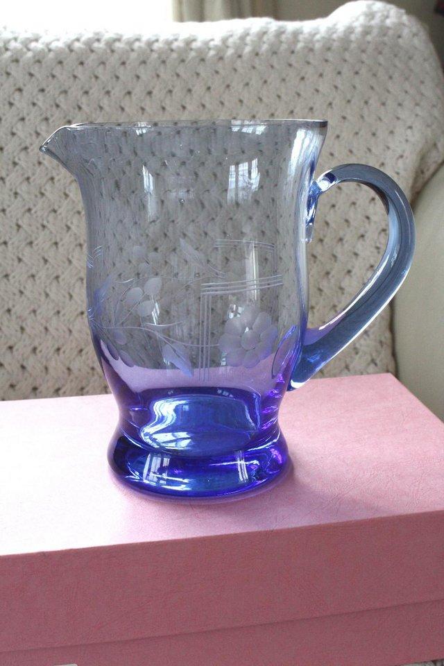 Preview of the first image of Large glass jug 7.5ins tall gradient blue & etched flowers.