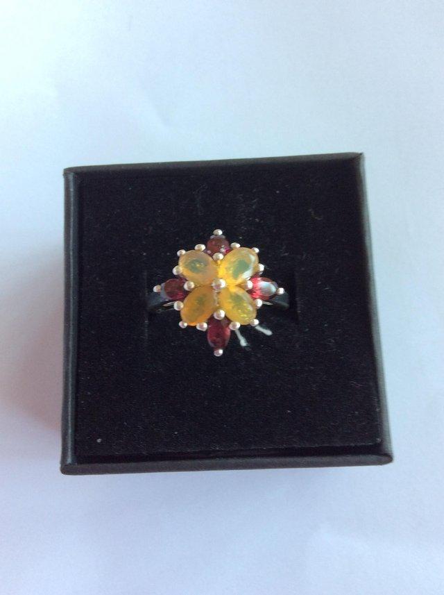 Preview of the first image of Imposing silver cluster ring with yellow and red stones.