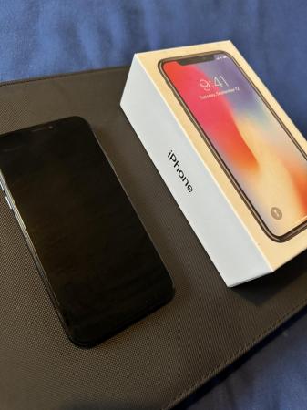 Image 1 of Black iPhone X and power adapter