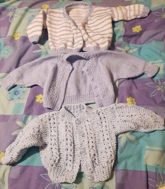 Preview of the first image of Baby boy blue hand knitted cardigans.