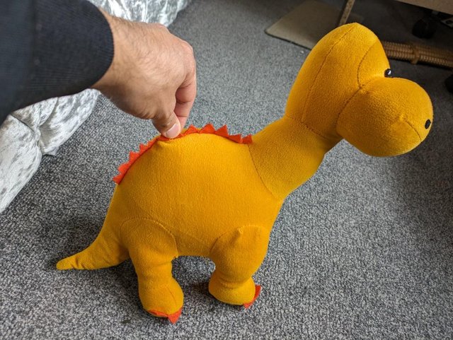 Preview of the first image of Orange knitted diplodocus soft toy.
