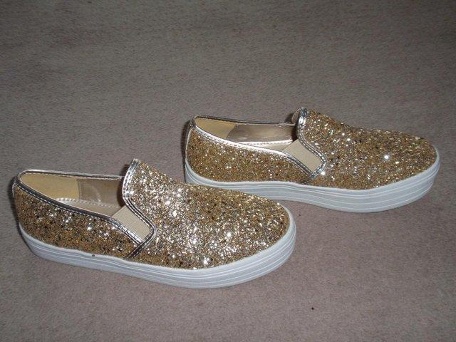 Preview of the first image of Gold Glitter Slip On Pumps with platform sole.