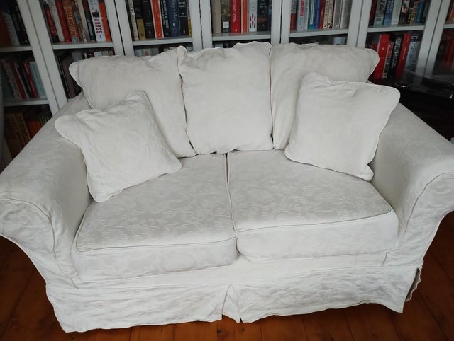 Preview of the first image of Cream fabric 2-seater sofa with cushions.
