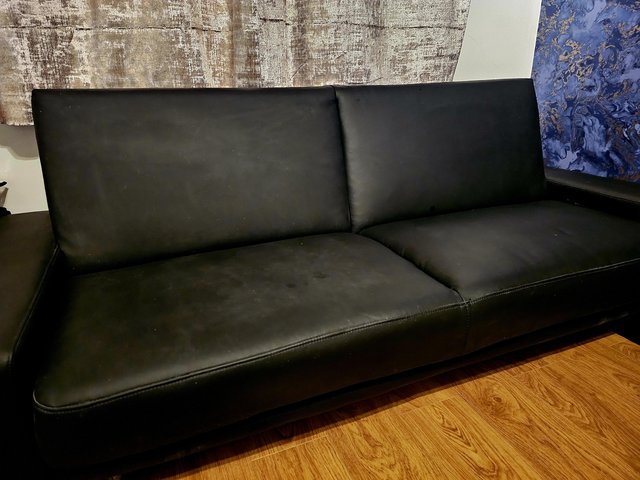 Preview of the first image of Hardly used black leather sofa bed.