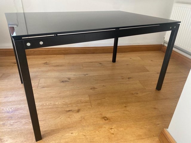Preview of the first image of Callagaris black glass top dining table.