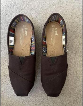 Image 1 of Toms canvas shoes in black.