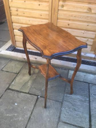 Image 1 of An attractive wooden table with nicely shaped top and legs.
