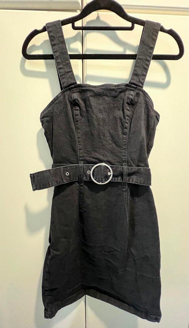 Preview of the first image of Black denim pinafore dress size 8.