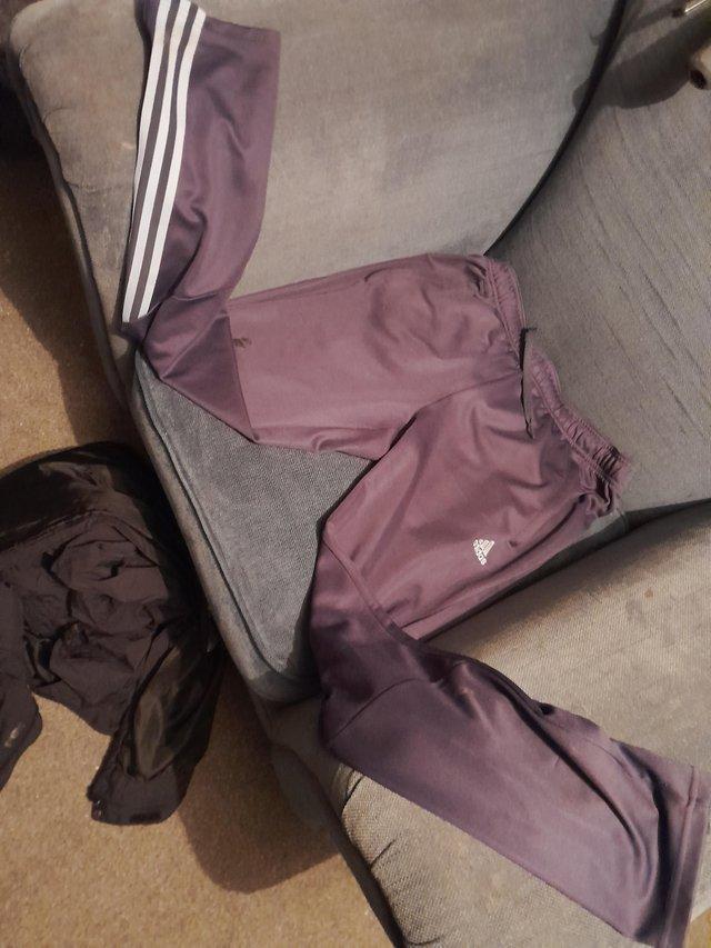 Preview of the first image of A dark bluey grey pair of adidas bottoms.