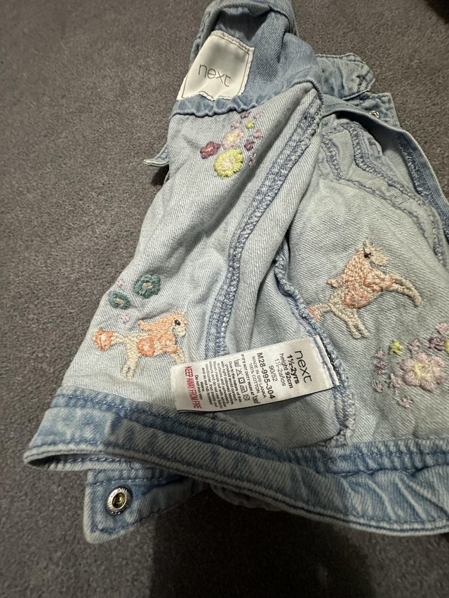 Preview of the first image of Next Denim Jacket with unicorn and pink flowers on.