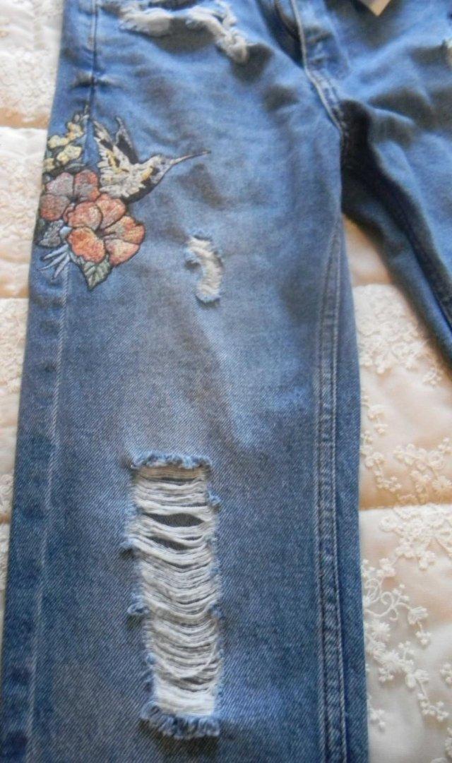Preview of the first image of Girls faded and scuffed embroidered denim jeans.